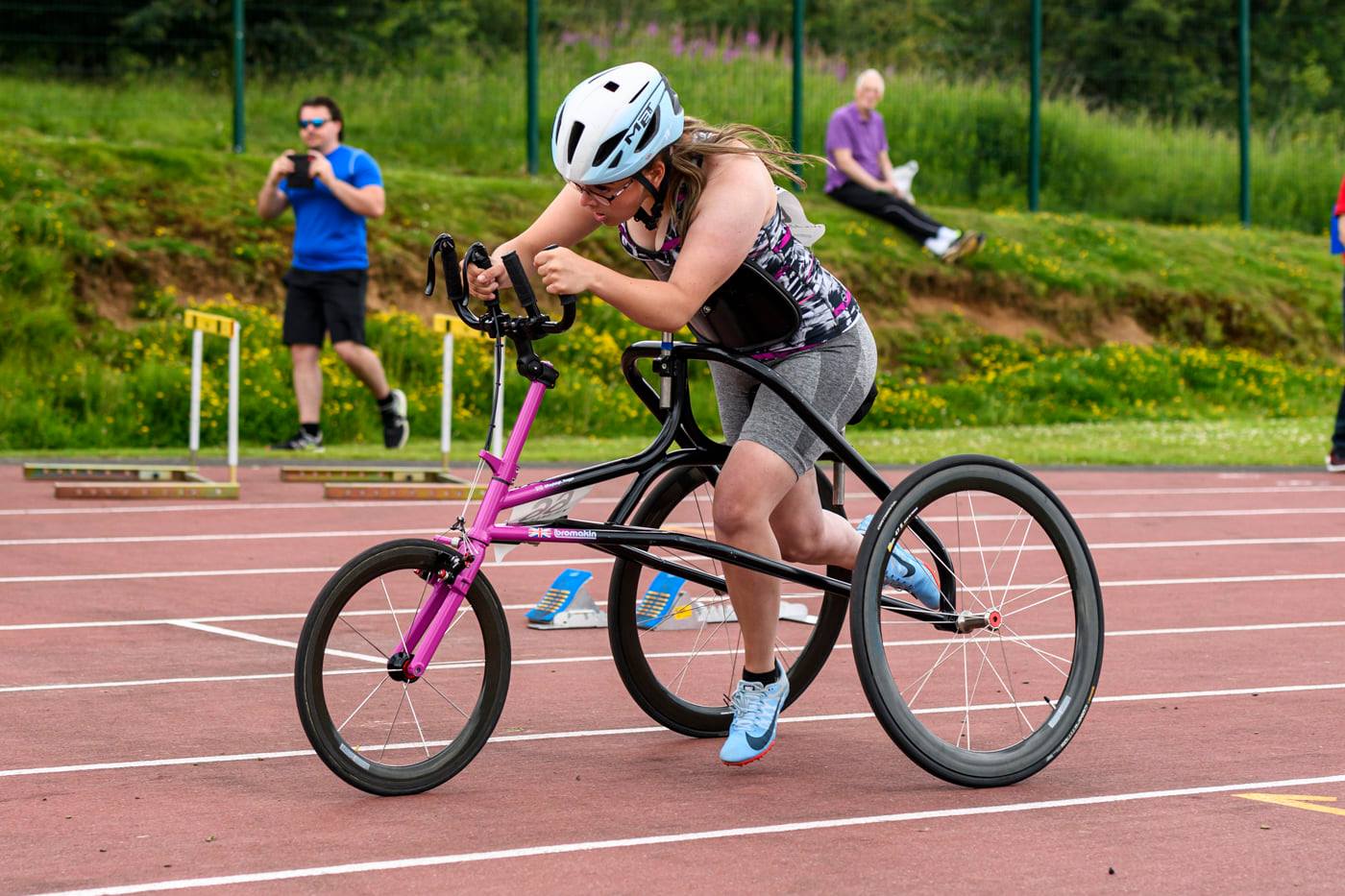 A woman running using adaptive equipment on a track